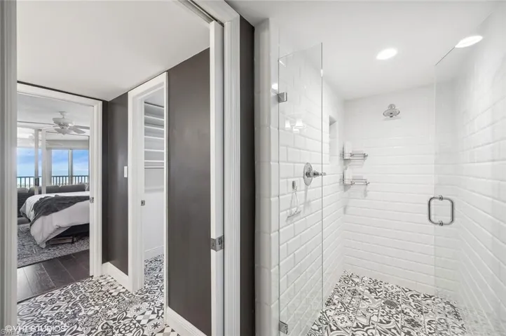 Bathroom with ceiling fan, wood-type flooring, and an enclosed shower
