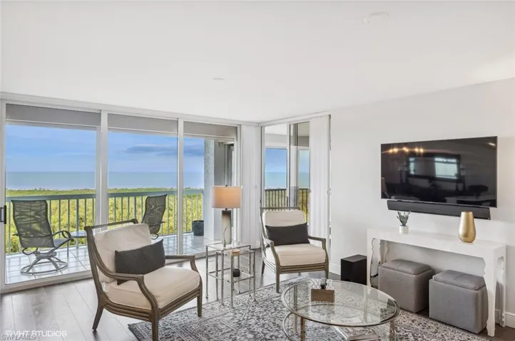 Living room featuring hardwood / wood-style flooring, expansive windows, and a water view