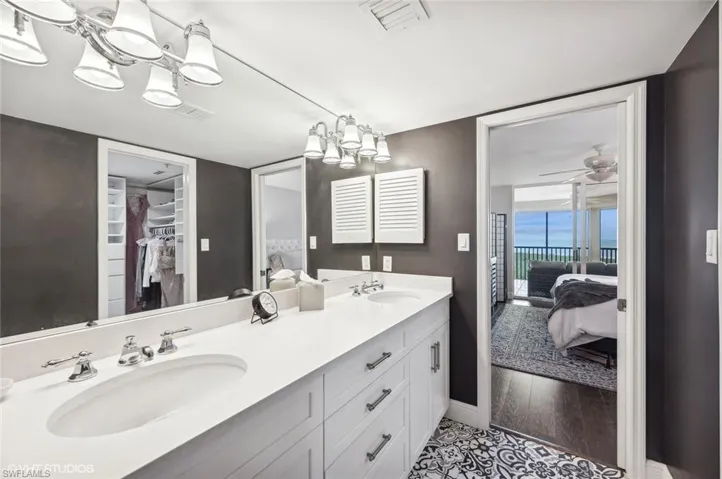 Bathroom featuring vanity, ceiling fan with notable chandelier, and hardwood / wood-style flooring