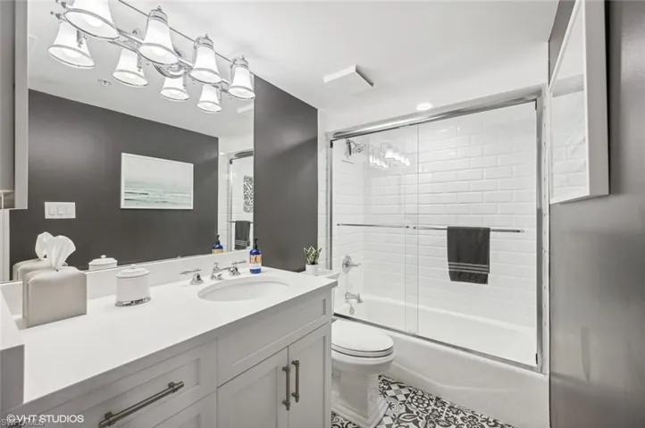 Full bathroom featuring vanity, toilet, and enclosed tub / shower combo