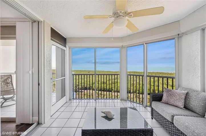 Sunroom featuring ceiling fan and a water view