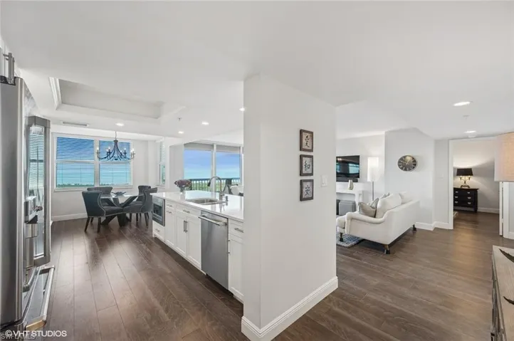 Kitchen with sink, dark hardwood / wood-style floors, a tray ceiling, white cabinets, and appliances with stainless steel finishes