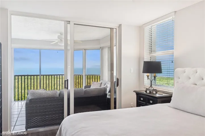 Bedroom featuring access to exterior, ceiling fan, a water view, and hardwood / wood-style flooring