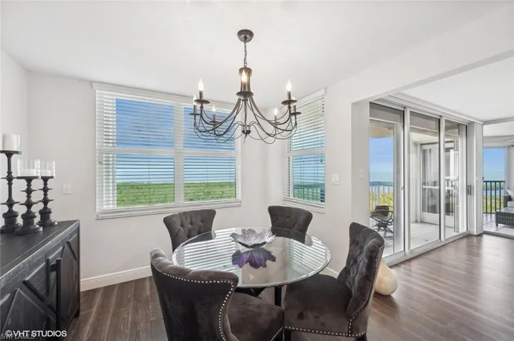 Dining room with a chandelier, dark hardwood / wood-style flooring, and a wealth of natural light