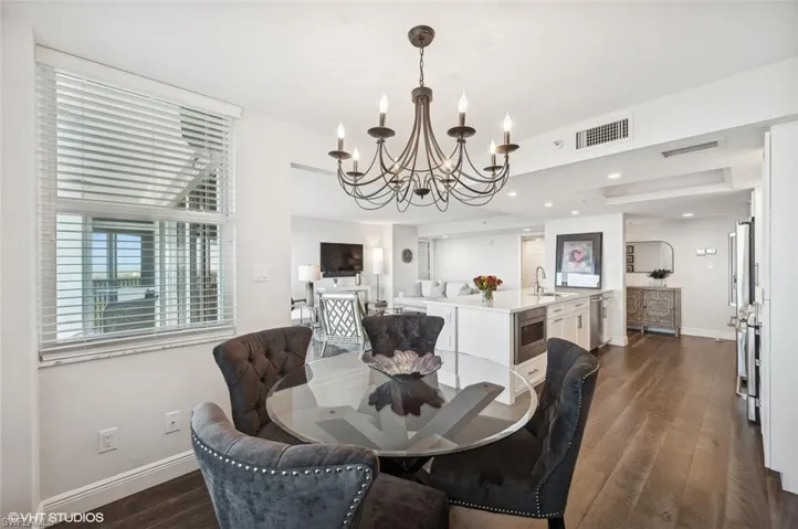 Dining space with dark hardwood / wood-style flooring, sink, and a chandelier