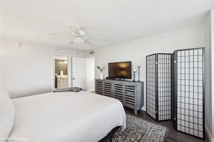 Bedroom featuring connected bathroom, ceiling fan, and dark wood-type flooring