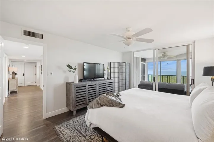 Bedroom featuring access to exterior, ceiling fan, and dark hardwood / wood-style flooring