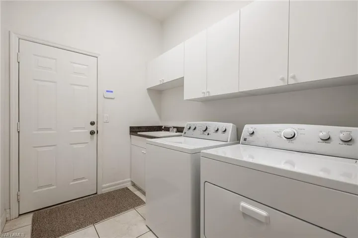 Laundry room with plenty of cabinets and laundry tub.