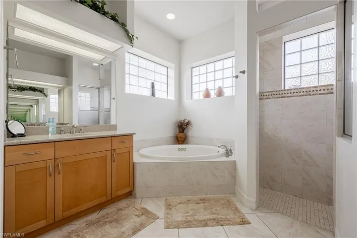 Bathroom with jetted soaking tub, dual vanities, and spacious walk-in shower.