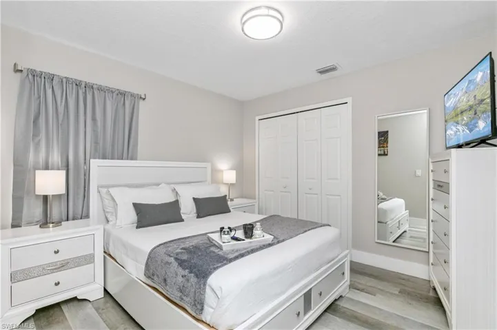 Bedroom featuring light wood-style floors, a textured ceiling, and a closet