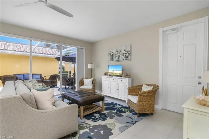Living area with a sunroom, a ceiling fan, and light tile patterned floors