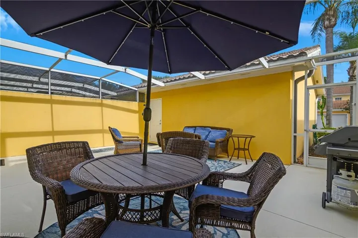 View of patio / terrace featuring glass enclosure, outdoor dining space, grilling area, and a sunroom