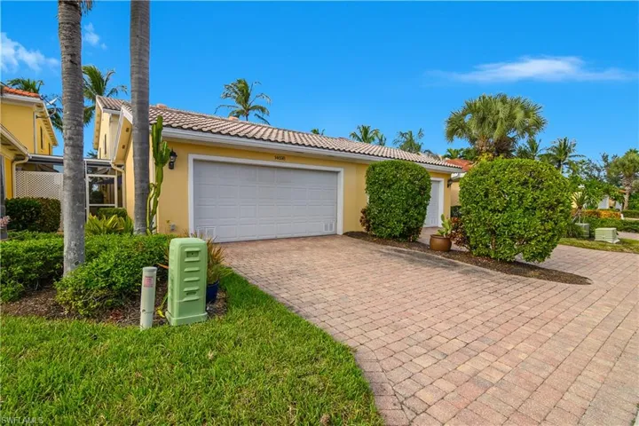 View of front of home featuring decorative driveway, an attached garage, stucco siding, and a tile roof
