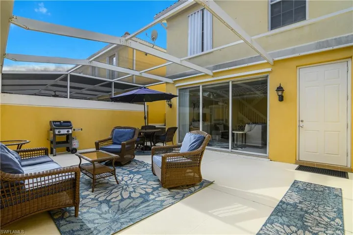 View of patio with glass enclosure, a sunroom, grilling area, and outdoor lounge area