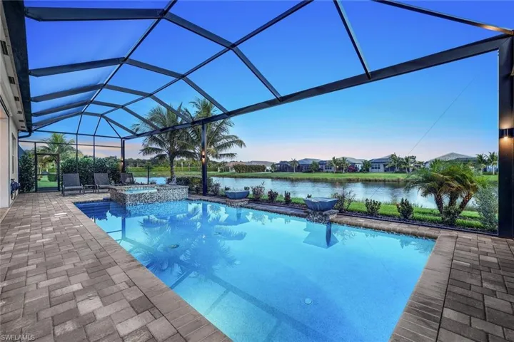 View of swimming pool featuring an in ground hot tub, panoramic screen enclosure, and a patio area