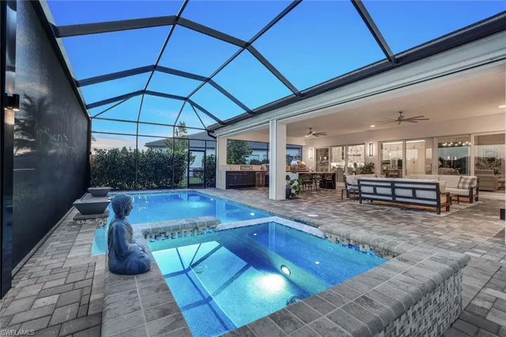 Pool at dusk with a lanai, a patio area, an outdoor living space, and ceiling fan