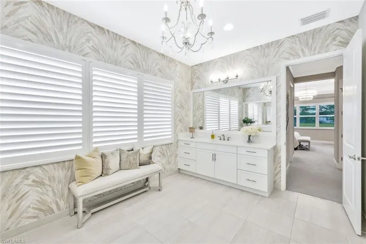 Bathroom with tile patterned floors, vanity, and an inviting chandelier