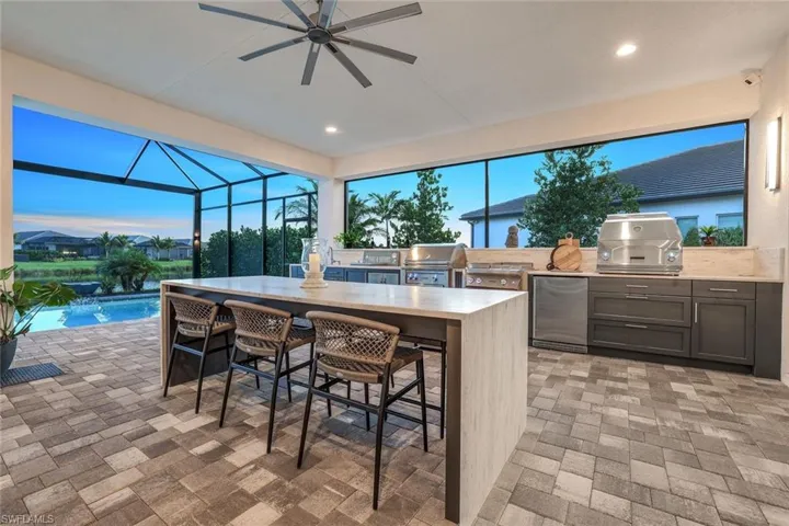 bar, a water view, and ceiling fan