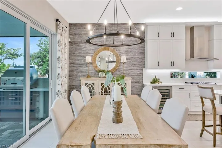 Tiled dining space with a chandelier and beverage cooler