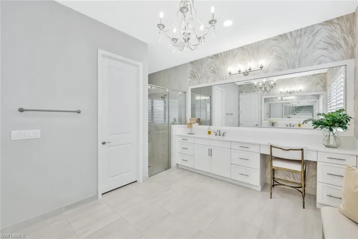Bathroom featuring vanity, an enclosed shower, tile patterned flooring, and a notable chandelier