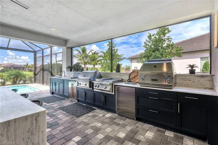 View of patio / terrace with exterior kitchen, screened enclosure, area for grilling, and sink