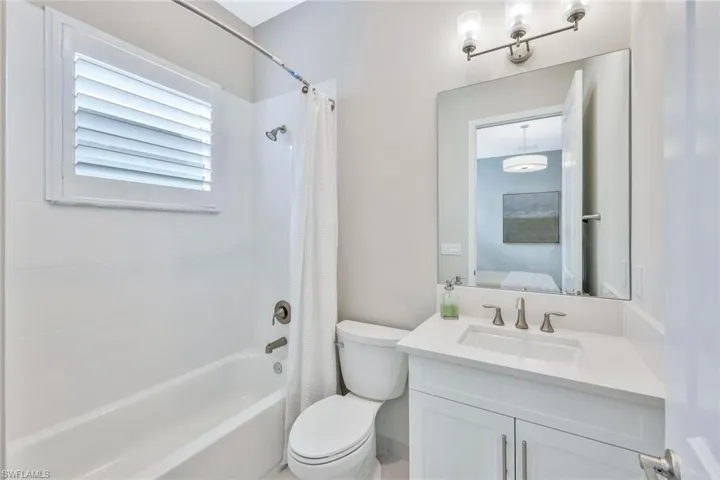 Full bathroom with vanity, shower / tub combo with curtain, and toilet