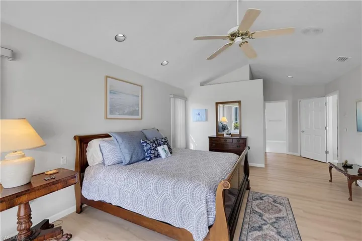 Bedroom with light wood finished floors, ceiling fan, recessed lighting, and vaulted ceiling