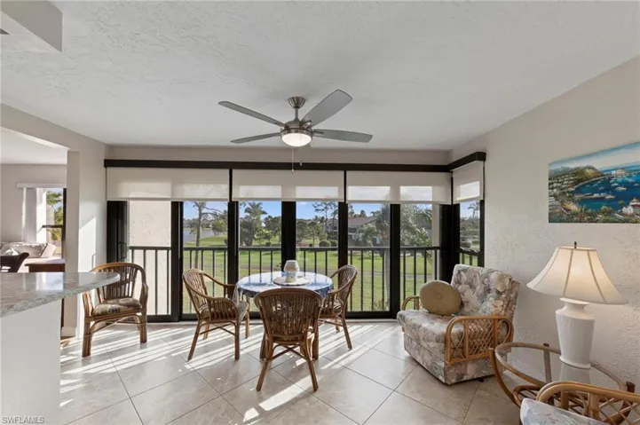 Ceramic tile flooring, floor-to-ceiling multi-panel hurricane glass sliders, dressed with custom electric indoor shades.
