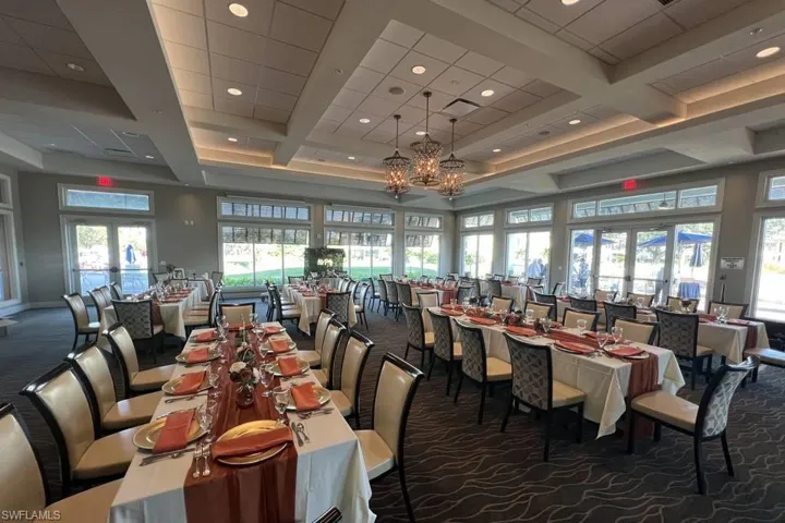 Spacious multi-purpose room featuring a coffered ceiling with recessed lighting, custom chandelier fixtures, wall-to-wall carpeting, and multiple sets of glass-paneled double doors