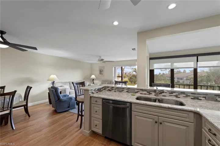 This Kitchen features an undermount double-basin stainless steel sink, tile backsplash, cabinetry with decorative molding, and stainless steel appliances.