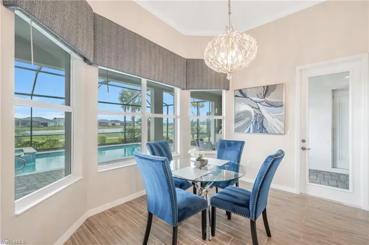 Dining room featuring crown molding, a notable chandelier, and light wood-type flooring