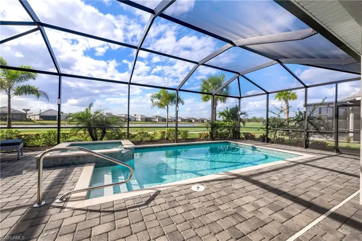 View of pool featuring glass enclosure, an in ground hot tub, and a patio
