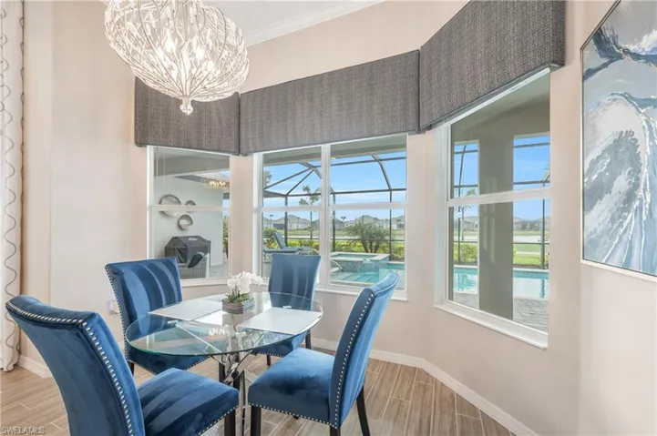 Dining area with crown molding, wood-type flooring, and an inviting chandelier