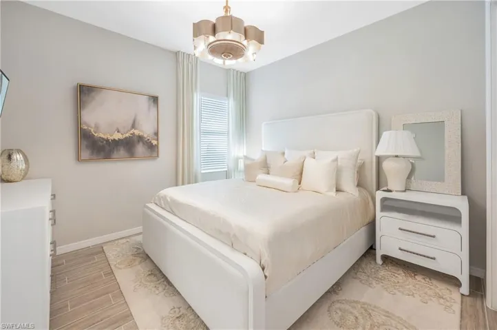 Bedroom featuring light hardwood / wood-style floors and ceiling fan with notable chandelier this is a king size bed!! Look at the fixture!!!!!!!!!!