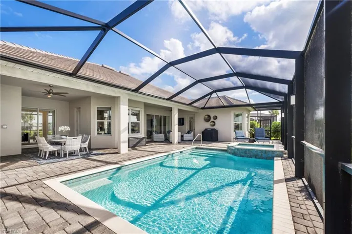 View of swimming pool featuring ceiling fan, a patio area, a lanai, and an in ground hot tub