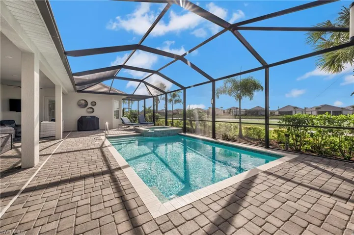 View of swimming pool featuring a lanai, an in ground hot tub, and a patio