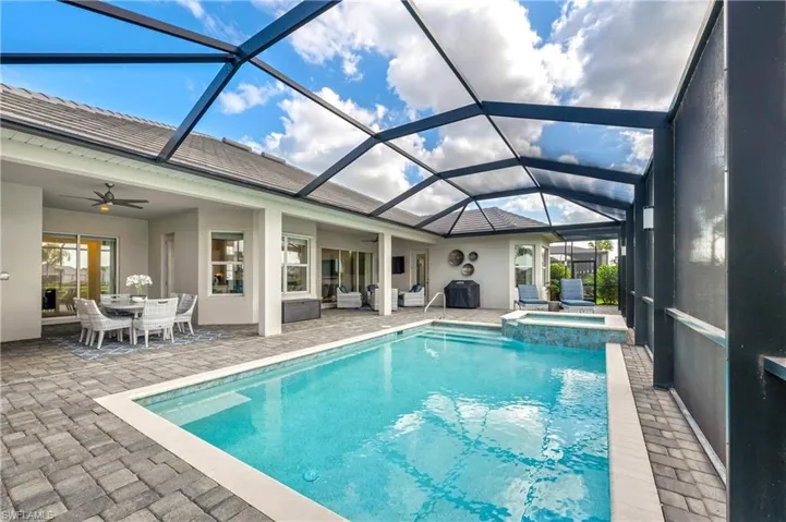 View of pool with ceiling fan, a patio area, a lanai, and an in ground hot tub