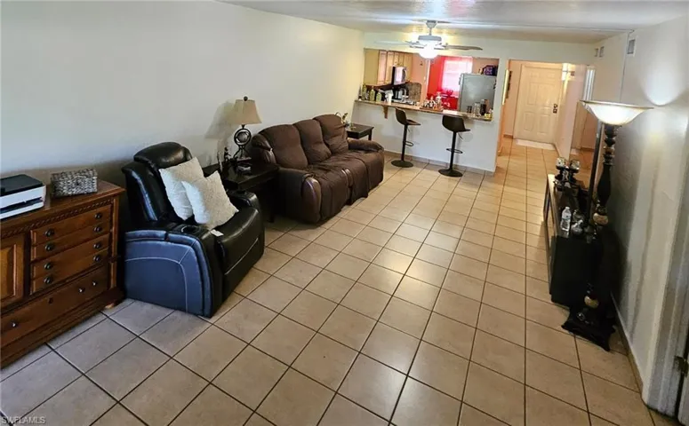 Living room with light tile patterned flooring and ceiling fan