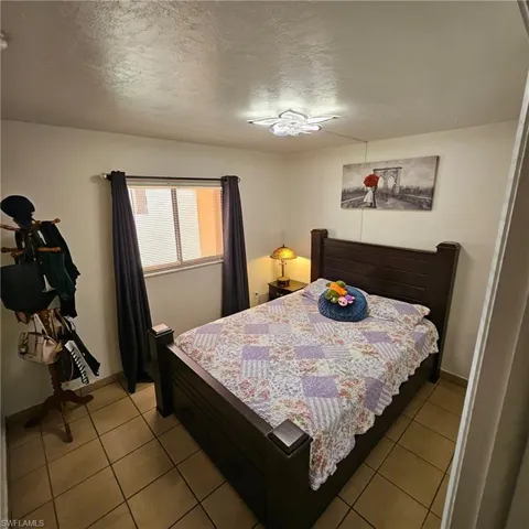 Bedroom featuring light tile patterned flooring and a textured ceiling