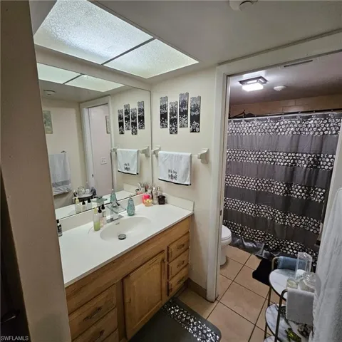 Bathroom with vanity, tile patterned floors, a textured ceiling, and toilet