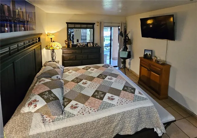 Bedroom with tile patterned floors and access to outside