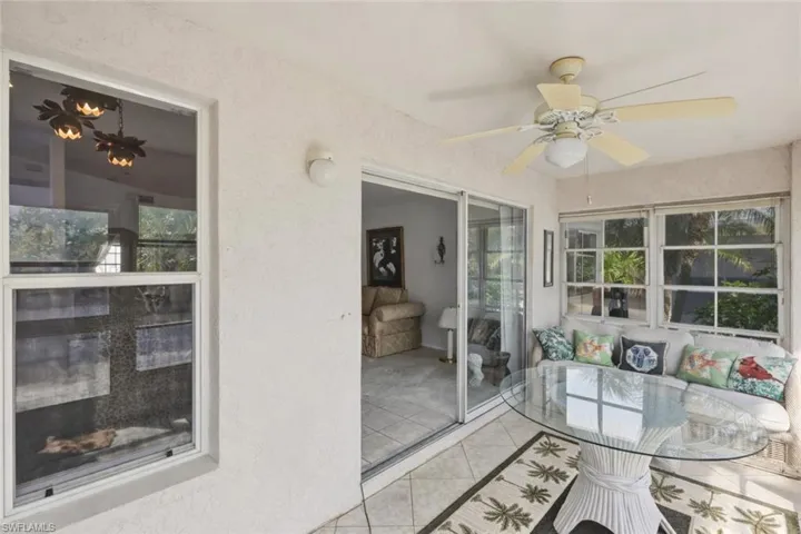 Sunroom featuring ceiling fan, a patio, and healthy amount of natural light
