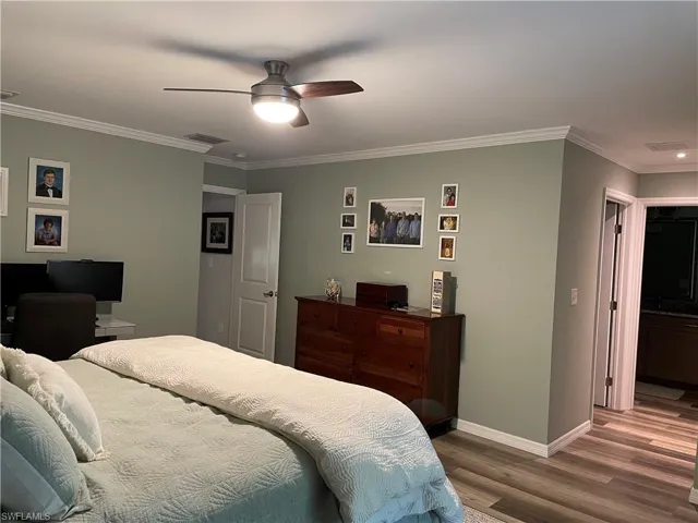 Bedroom featuring ceiling fan, hardwood / wood-style floors, and crown molding