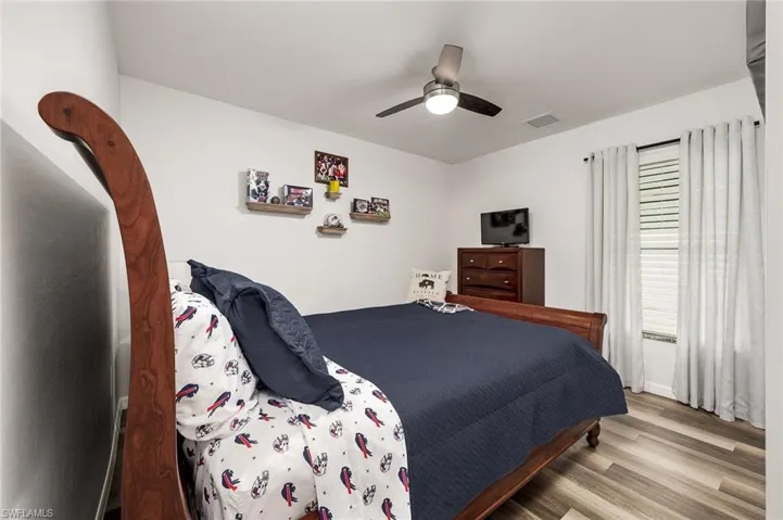Bedroom with ceiling fan and hardwood / wood-style floors