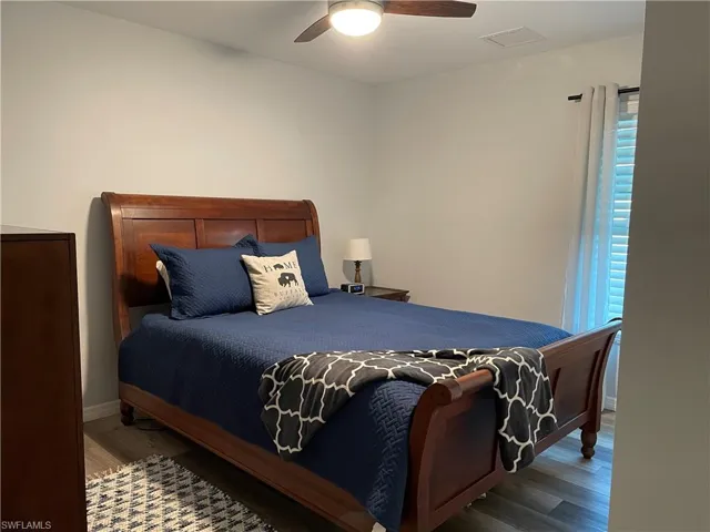 Bedroom featuring ceiling fan and dark wood-type flooring