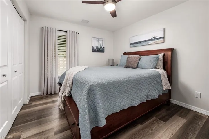 Bedroom with a closet, ceiling fan, and dark wood-type flooring