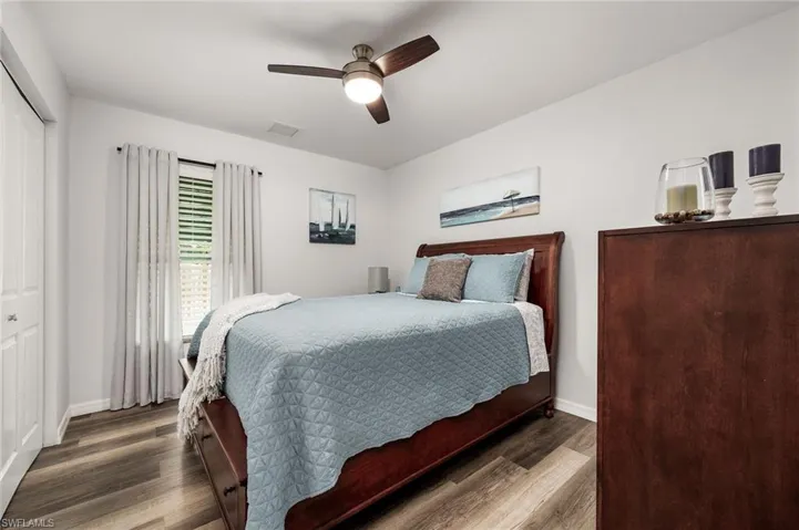 Bedroom featuring ceiling fan, a closet, and dark wood-type flooring