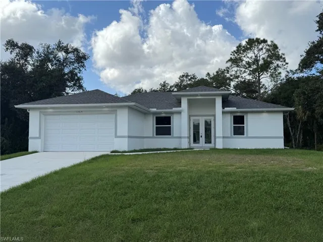 View of front facade featuring a front lawn and a garage