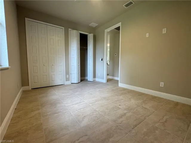 Unfurnished bedroom featuring multiple closets