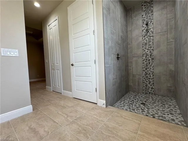 Bathroom featuring tile patterned floors and a tile shower